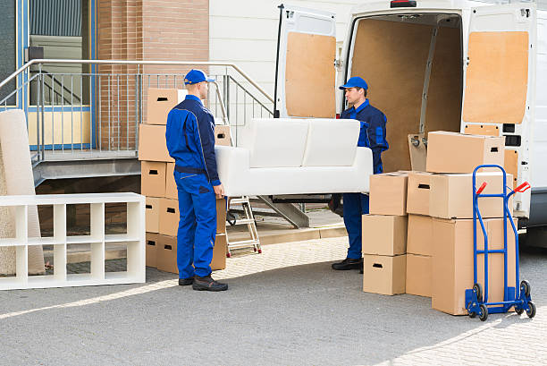 full length of young male movers carrying sofa outside truck on street