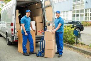 rsz two happy male movers in front of truck with stack of cardboard boxes 42192582 xxl 810x540